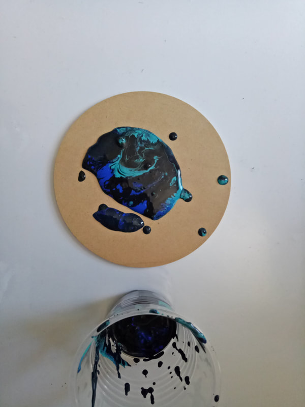 Picture of black, turquoise and ultramarine poured on coaster