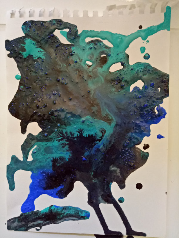 Picture of paint tilted over surface of paper, creating an abstract shape